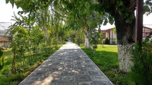 a walkway lined with trees in a yard at Cross Resort Hotel in Yerevan
