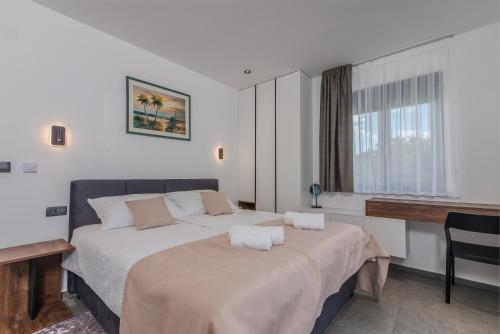 Un dormitorio con una cama con dos toallas encima. en Villa Taralis with heated pool, en Kaštel