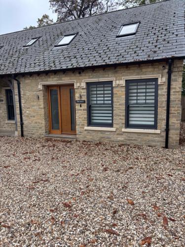 a house with windows and a roof on a pile of gravel at The Annexe, The Walled Garden- Nr Bicester Village in Bicester