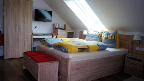 Schlafzimmer mit einem Bett mit gelben und blauen Kissen in der Unterkunft Urlaub mit Alpakas in Sabrodt