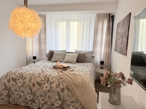 een slaapkamer met een bed en een kroonluchter bij BIELEFELD CITY APARTMENTS - Cozy in Bielefeld