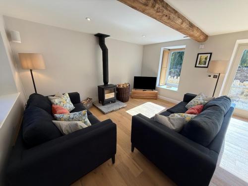 a living room with two couches and a fireplace at Recently converted barn on the outskirts of Bath in Radstock