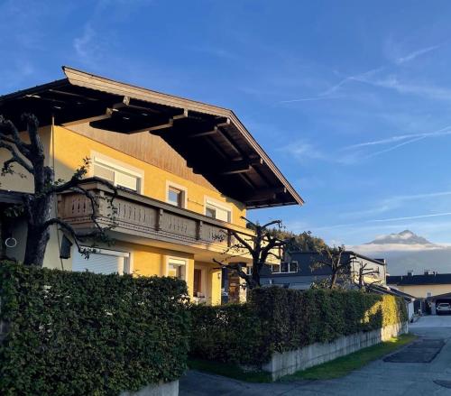 a yellow house with awning on the side of it at Ferienwohnung Auszeit in Kirchdorf in Tirol