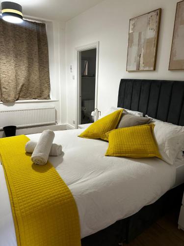 a bed with yellow and white pillows on it at Kingfield Boutique Hotel in Sheffield