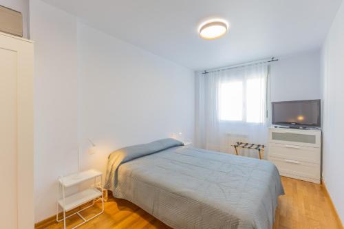 a bedroom with a bed and a flat screen tv at Holidea Liencres in Liencres