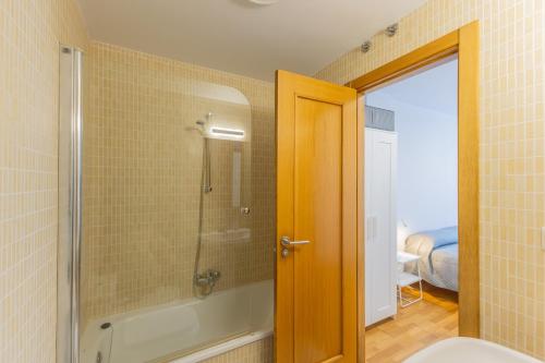a bathroom with a shower and a bath tub at Holidea Liencres in Liencres