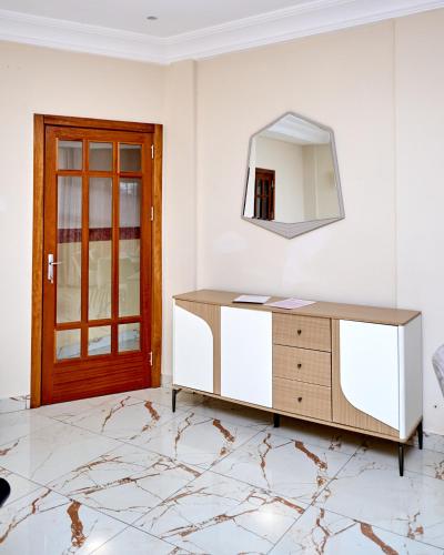 a mirror and a dresser in a room with a door at Résidence meublée kribi in Kribi
