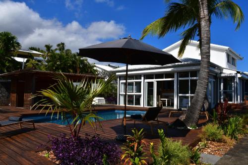 una casa con ombrellone e piscina di Villa Kokoro a Saint-Paul