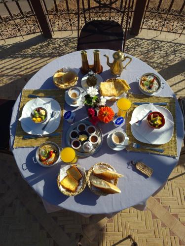 una mesa azul con platos de comida. en Palm Dades, en Boumalne