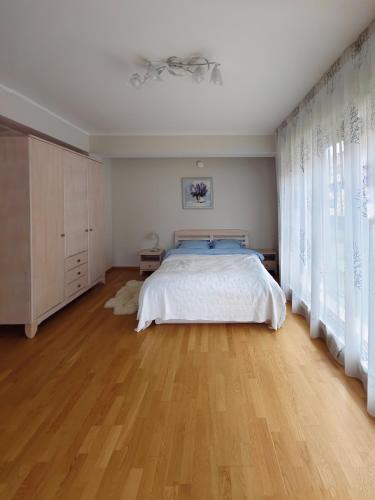 a bedroom with a bed and a wooden floor at Costa del Sol Apartment in Saulkrasti