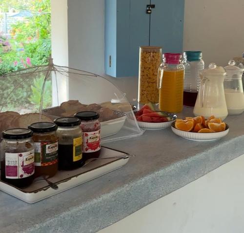 a counter with jars and plates of food on it at Allamanda Boutique Hostel in Galu