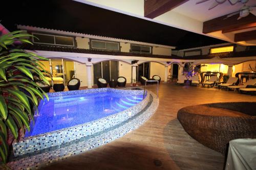 uma piscina numa sala com cadeiras e mesas em Cedros Inn Boutique Hotel em Guayaquil