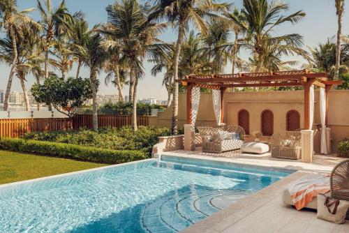 a swimming pool with a gazebo and a resort at One&Only The Palm Dubai in Dubai