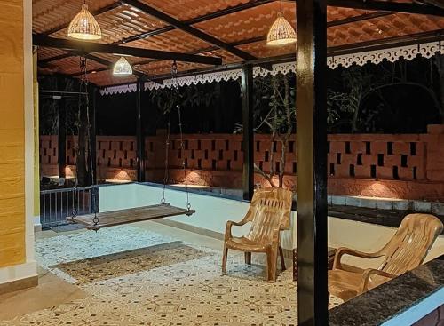 two chairs sitting in front of a swimming pool at Saraswati Vinayak Villa in Dapoli, Konkan in Dapoli