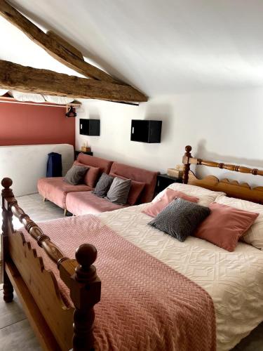 a bedroom with two beds and a couch at L’Atelier de René Futuroscope in Beaumont