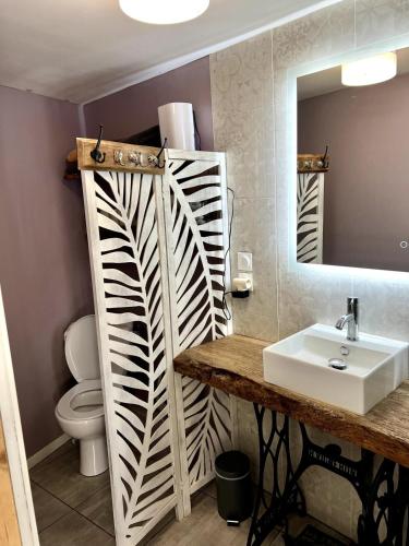 a bathroom with a white sink and a mirror at L’Atelier de René Futuroscope in Beaumont