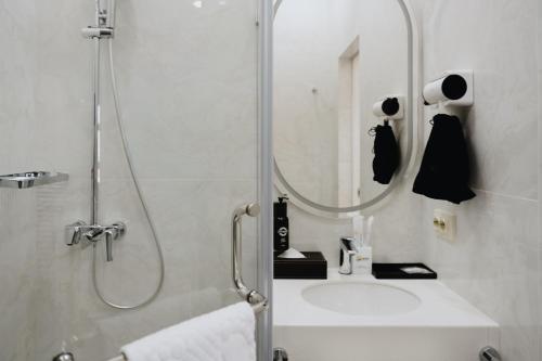 une salle de bain avec une douche, un lavabo et un miroir dans l'établissement Bon Hotel Bishkek, à Bishkek