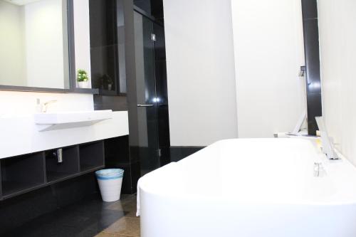 a white bathroom with a sink and a toilet at KLCC Sky Villa Suites The Mews in Kuala Lumpur