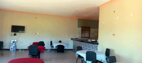 a room with chairs and a table and a fireplace at Lexus Motel Rwamwanja in Kamwenge