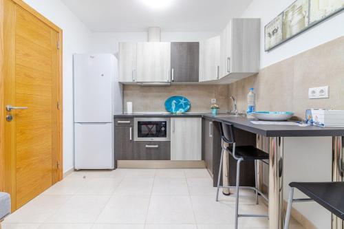 Una cocina con un refrigerador blanco y una encimera. en Arinaga Playa 4, en Agüimes