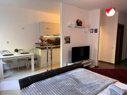 a living room with a bed and a kitchen with a table at 13StudioBv in Braşov