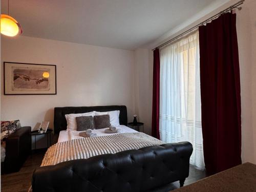 a bedroom with a bed with a couch and a window at 13StudioBv in Braşov