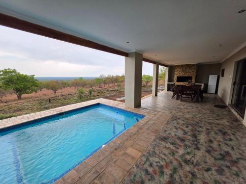 a swimming pool with a view of the ocean at Klipdrift Sands Game Lodge in Dinokeng Game Reserve