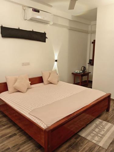 a large bed in a room with at Old Bridge Riverside Hotel in Kitulgala