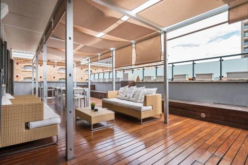 a living room with a couch and tables on a building at Great apartment with a pool on the beach in Barcelona in Badalona