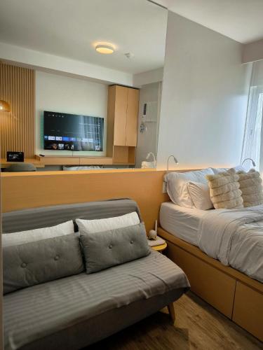 a bedroom with a bed and a couch and a tv at Prime Zen in Silang