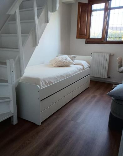 a white bed in a room with stairs at Fienile Paradiso Home Tuscany in Campi Bisenzio
