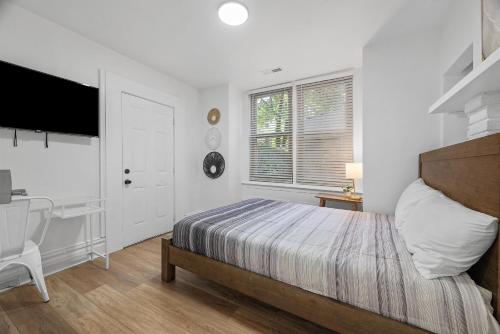 a bedroom with a bed and a desk and a television at Pittsburgh Shadyside 1E Bright and Modern Private Bedroom with Shared Bathroom in Pittsburgh