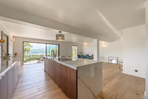 cocina y sala de estar con encimera grande en Villa Panoramiqua - Vue 180 sur le Lac d'Annecy et les montagnes, en Saint-Jorioz