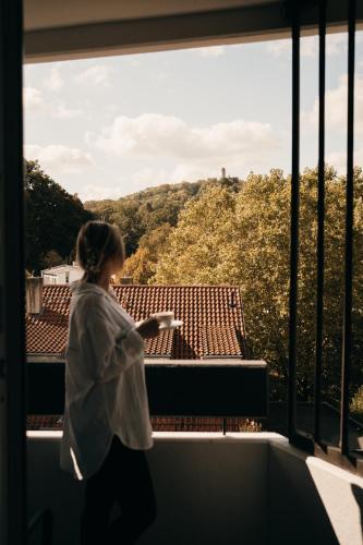 a woman walking on a balcony looking out a window at Das HOB - Hotel Original Bamberg in Bamberg