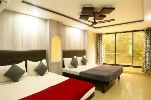 a bedroom with two beds and a window at Mottel AC Room with Breakfast at Calangute in Calangute