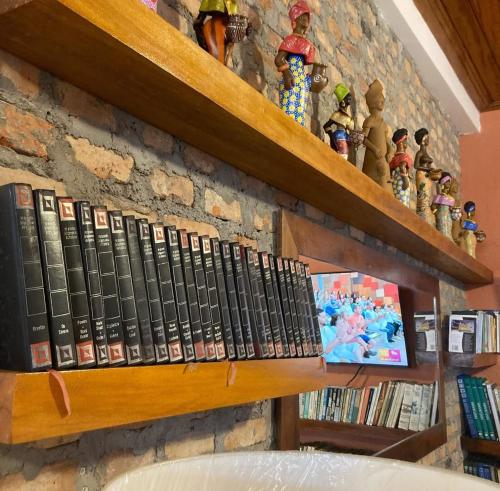 a bunch of books sitting on a shelf at Residencial João Nunes Netto in Laguna