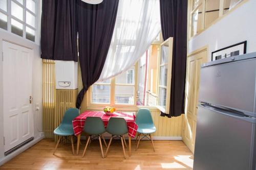 Una cocina con una mesa con sillas y un refrigerador. en Charming 2BR Apartment In Old Tbilisi - By Wehost, en Tiflis