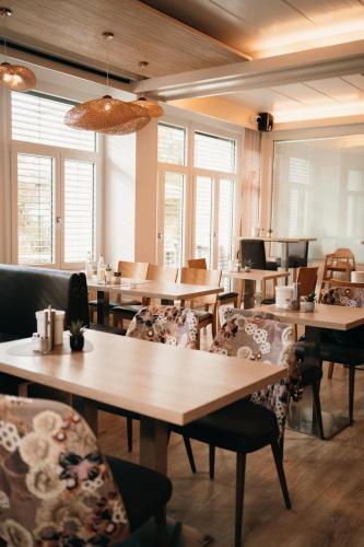 a restaurant with wooden tables and chairs and windows at Das HOB - Hotel Original Bamberg in Bamberg