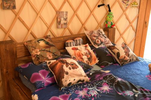 a bed with a bunch of pillows on it at 01 JURTA šedá u stodoly in Chotětice