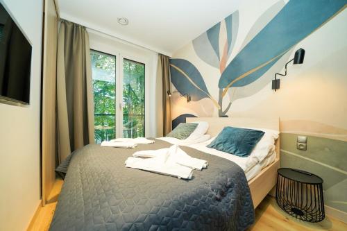 a bedroom with a bed with towels on it at Seaside Garden by Baltic Home Świnoujście in Świnoujście