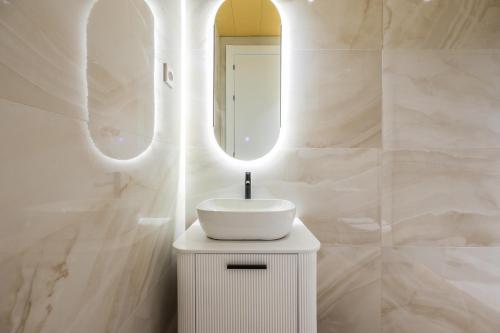a white bathroom with a sink and a mirror at AmazINN Collection Madrid Plaza Mayor in Madrid