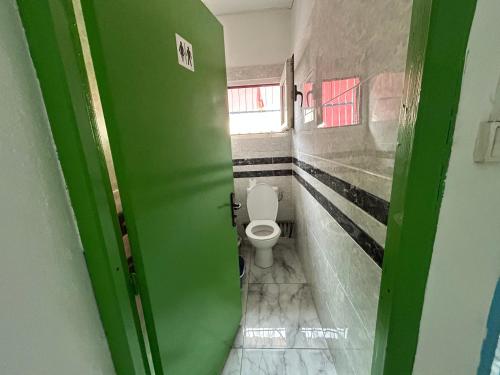 a green door to a bathroom with a toilet at Steiladay hébergement 976 in Pamandzi