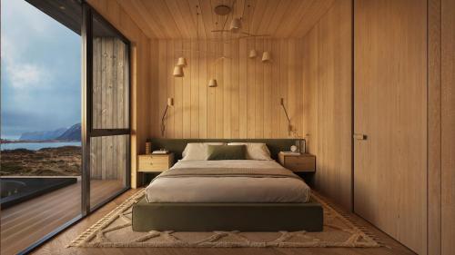 a bedroom with a bed and a large window at Lodge 11 - Amazing cabin in Lyngvær in Storøya