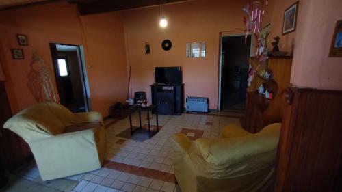 Una sala de estar con dos sillas y un televisor. en La casa de David, en Deán Funes