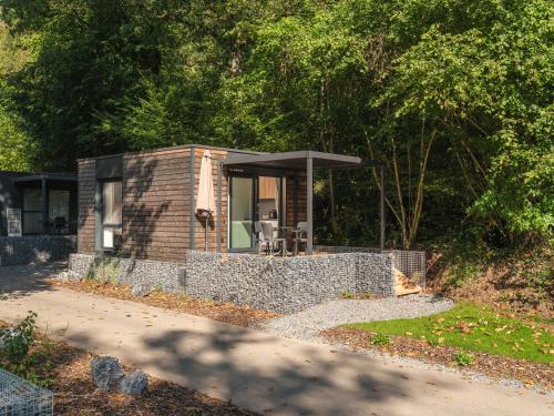 een klein bakstenen huisje met een zwart dak bij Tiny House | 2 personen in Tandel