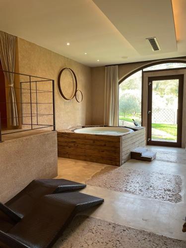 a bedroom with a large bed and a large window at Massimago Wine Relais in Mezzane di Sotto