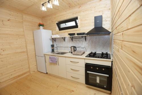 eine kleine Küche mit einem Herd und einem Kühlschrank in der Unterkunft Cottage in Forest Wave - კოტეჯი ტყის ტალღებში in Grigoleti