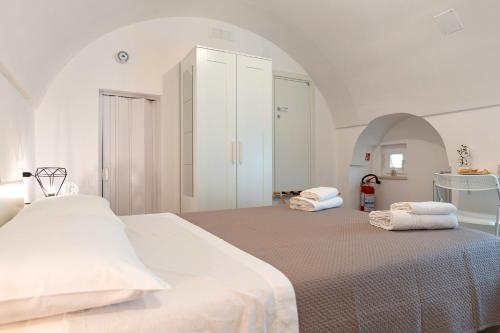 a white bedroom with a large bed with towels on it at Suite Le Cementine in Mottola