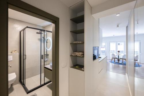 un bagno con doccia in vetro e una sala da pranzo di C Street Studio a Pristina