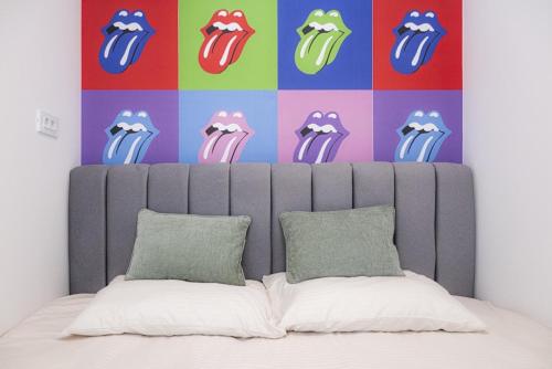 una testiera di un letto con una parete colorata di C Street Studio a Pristina